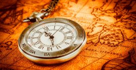 Vintage Antique pocket watch on an ancient world map in 1565..